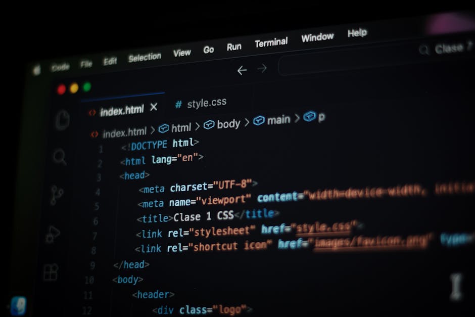 A close-up view of a partially visible laptop screen displaying lines of computer code in a dark-themed editor, positioned on a wooden surface. Next to the laptop, there is a ceramic coffee mug with a